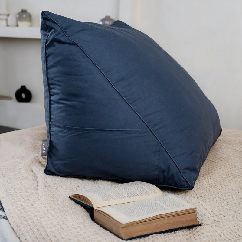 Leeskussen Bline, kleur Blauw, op een bed met een opengeslagen boek