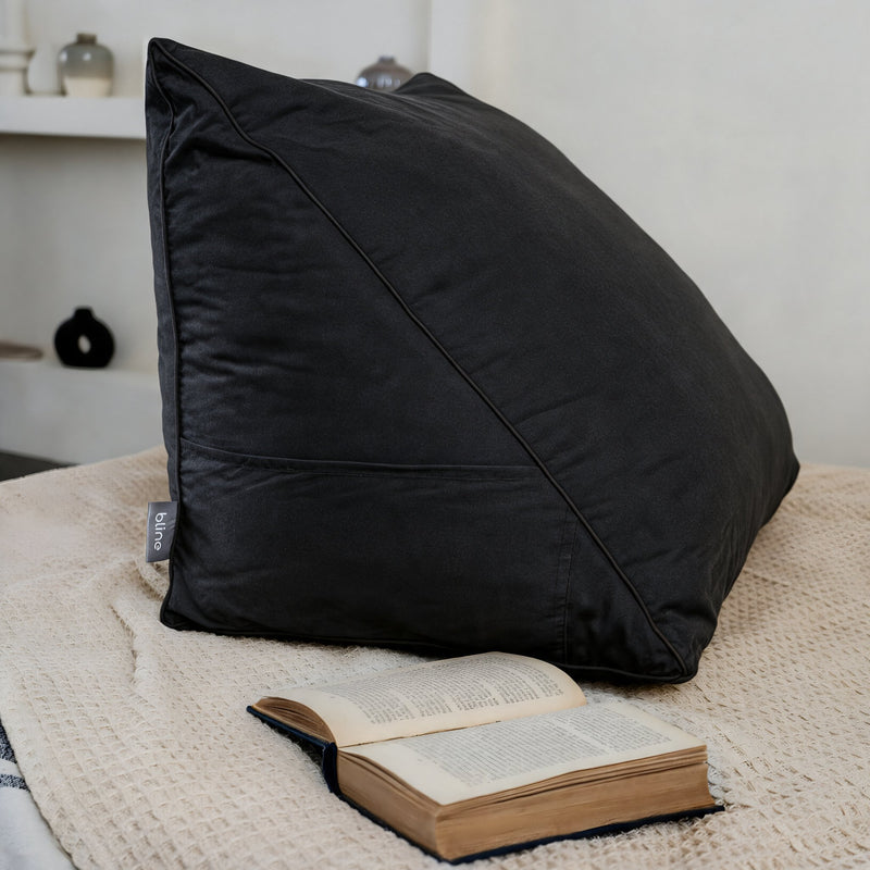 Leeskussen Bline, kleur Zwart, op een bed met een opengeslagen boek