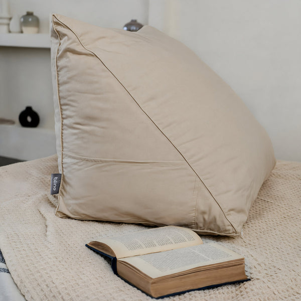 Bline leeskussen in beige op bed