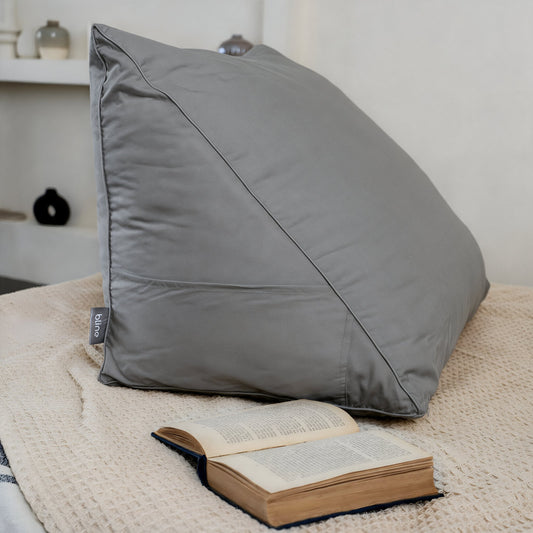 Leeskussen Bline, kleur Grijs, op een bed met een opengeslagen boek